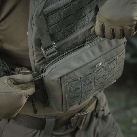 M-Tac Admin Pouch Large Elite käytössä taktisen varustuksen kanssa, valmistettu Cordura 500D:stä, velcro-panel ja säilytystilat.