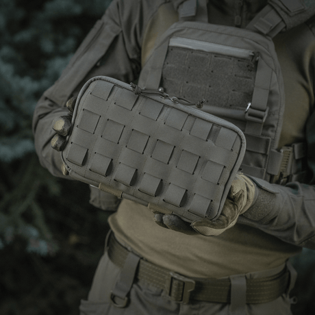 Henkilö pitää M-Tac Admin Pouch Large Elite -laukua, jossa laserskåret velcro-panel. Sopii taktiseen varusteen säilytykseen. Valmistettu Cordura 500D:stä.
