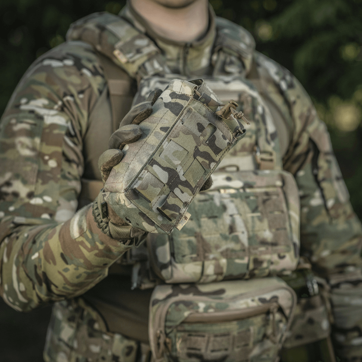 Person i camouflageuniform holder M-Tac Mediclomme Small Vertical Elite, en holdbar medicinlomme af Cordura 500D.