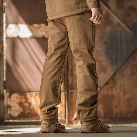 M-Tac Bukser Soft Shell Vinter i en industriel setting, der demonstrerer slidstyrken og komforten af softshell-materialet.
