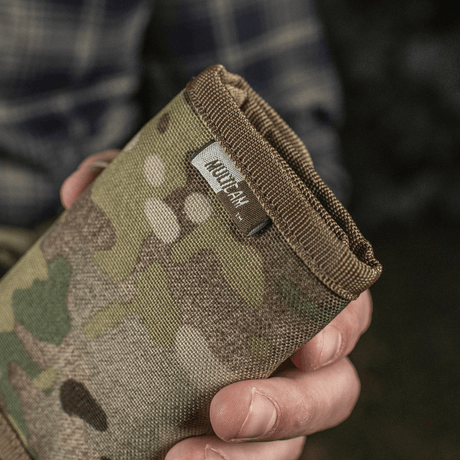 M-Tac Pung Elite Gen.II camo-mallissa kädessä pidettynä, valmistettu kestävästä Cordura 500D:stä, YKK-vetoketju.