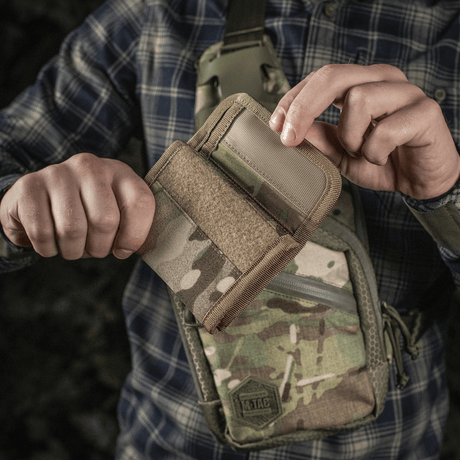 Henkilö pitelee M-Tac Pung Elite Gen.II:tä, valmistettu Cordura 500D:stä, M-Tac-logo ja YKK-vetoketjut. Sopii korteille, seteleille ja kolikoille.