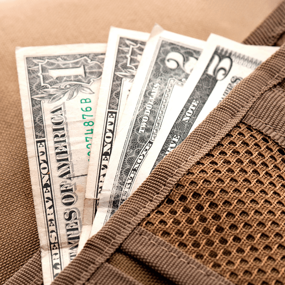 M-Tac Pung med Patch Panel Elite i militærstil, åben med synlige dollarsedler, viser robust CORDURA® konstruktion og Velcro-lukning.