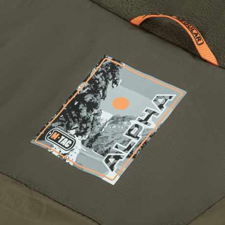 Logo af M-Tac Alpha Gen.III Pro Vinterjakke på jakken, viser mærke og stilfuldt design. Perfekt til vinterklima og hverdagsbrug.