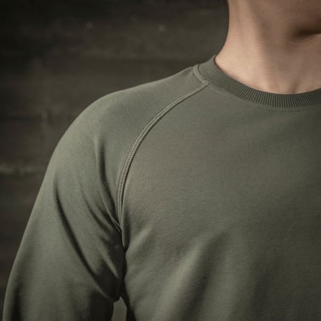 M-Tac Raglan Athlete oliivinvärisenä, minimalistinen college raglanhihoilla, sopii urheiluun ja arkipäivän käyttöön ympäri vuoden.