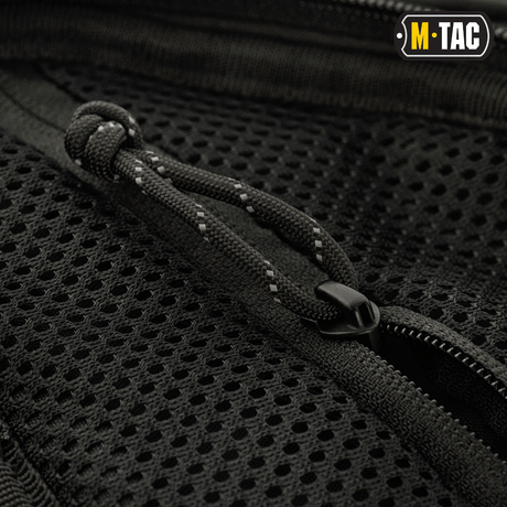 Lähikuva vetoketjusta ja rakenteesta M-Tac Buckler Taske Elite -laukun mustassa Cordura 500D -materiaalissa, näyttää yksityiskohtaisen muotoilun.