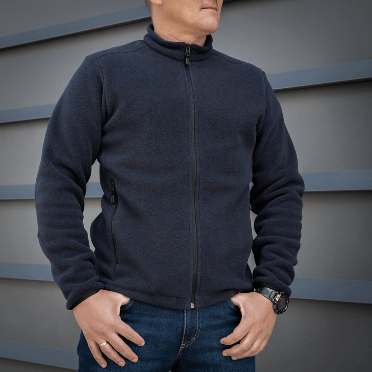 Mand iført M-Tac Nord Polartec Fleecejakke foran grå væg