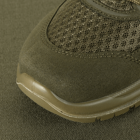 Nærbillede af M-Tac Tactical Sneakers IVA med åndbar mesh og forstærket tå for holdbarhed på grønt underlag.