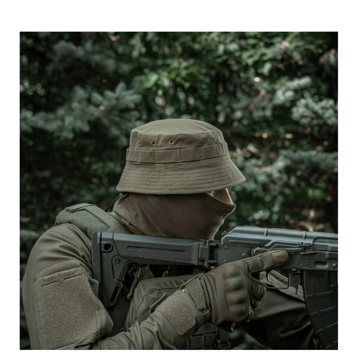 Person iført M-Tac Panamahat Gen. II Summer Flex i skovmiljø, klar til taktiske opgaver, fokus på komfort og kvalitet i varmt vejr.