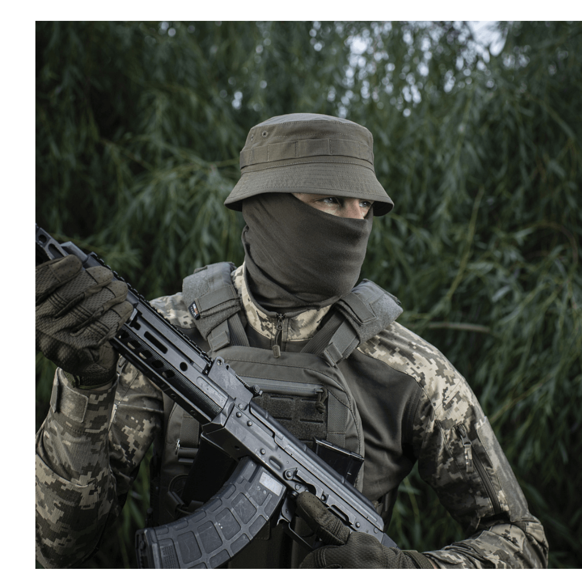 Soldat iført M-Tac Panamahat Gen. II Flex Rip-Stop med camouflage i naturmiljø.