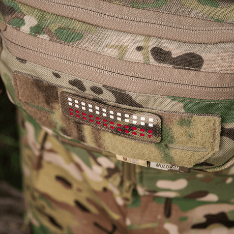 M-Tac Patch Flag 25x80 Mini Squares laserleikatulla designilla Cordura 500D-vaatteessa velcro-kiinnityksellä, maastotausta.