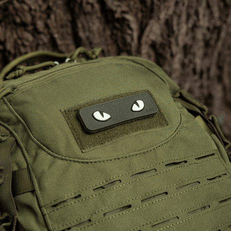 M-Tac Cat Eyes 3D PVC-patch vihreässä repussa puun vieressä.