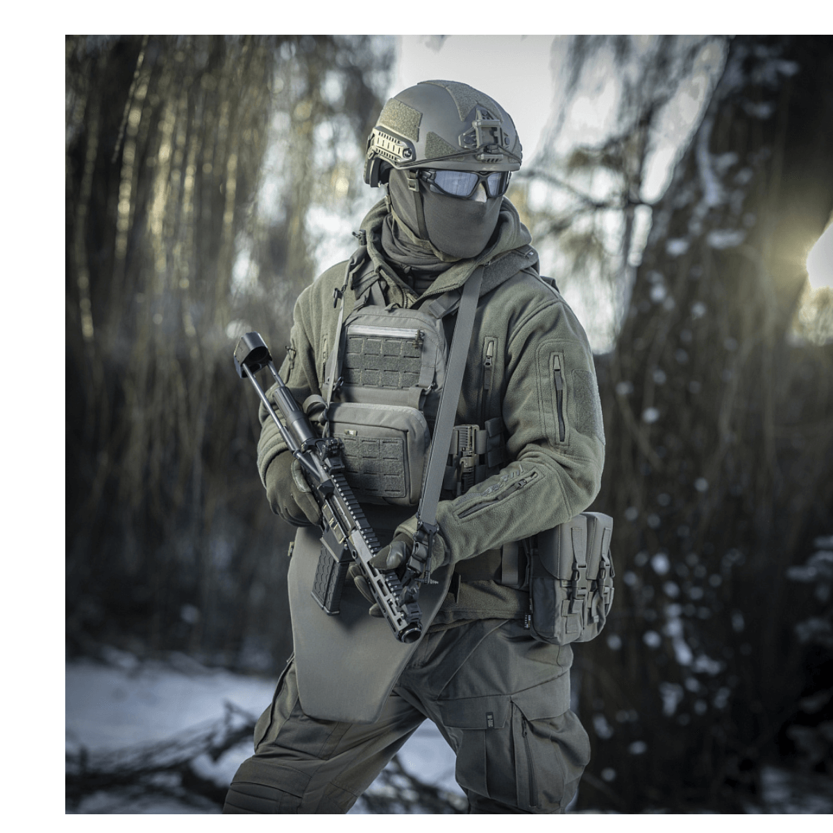 Soldat i vintermiljø med M-Tac Universal Våbenrem og taktisk udstyr til komfortabel geværhåndtering.