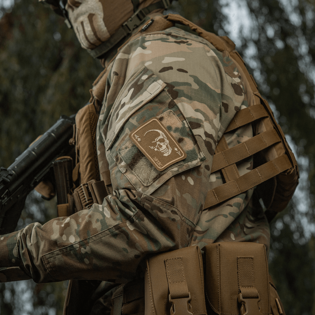 M-Tac Patch Face of War (Broderi) på en kamouflagejakke med et frygtløst kraniemotiv inspireret af Vietnamkrigens dødens kort.