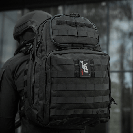 M-Tac Patch Bad Boy (kirjonta) kiinnitetty mustaan taktiseen reppuun, en, näyttää ace of spades -kuvion koiran kallolla.