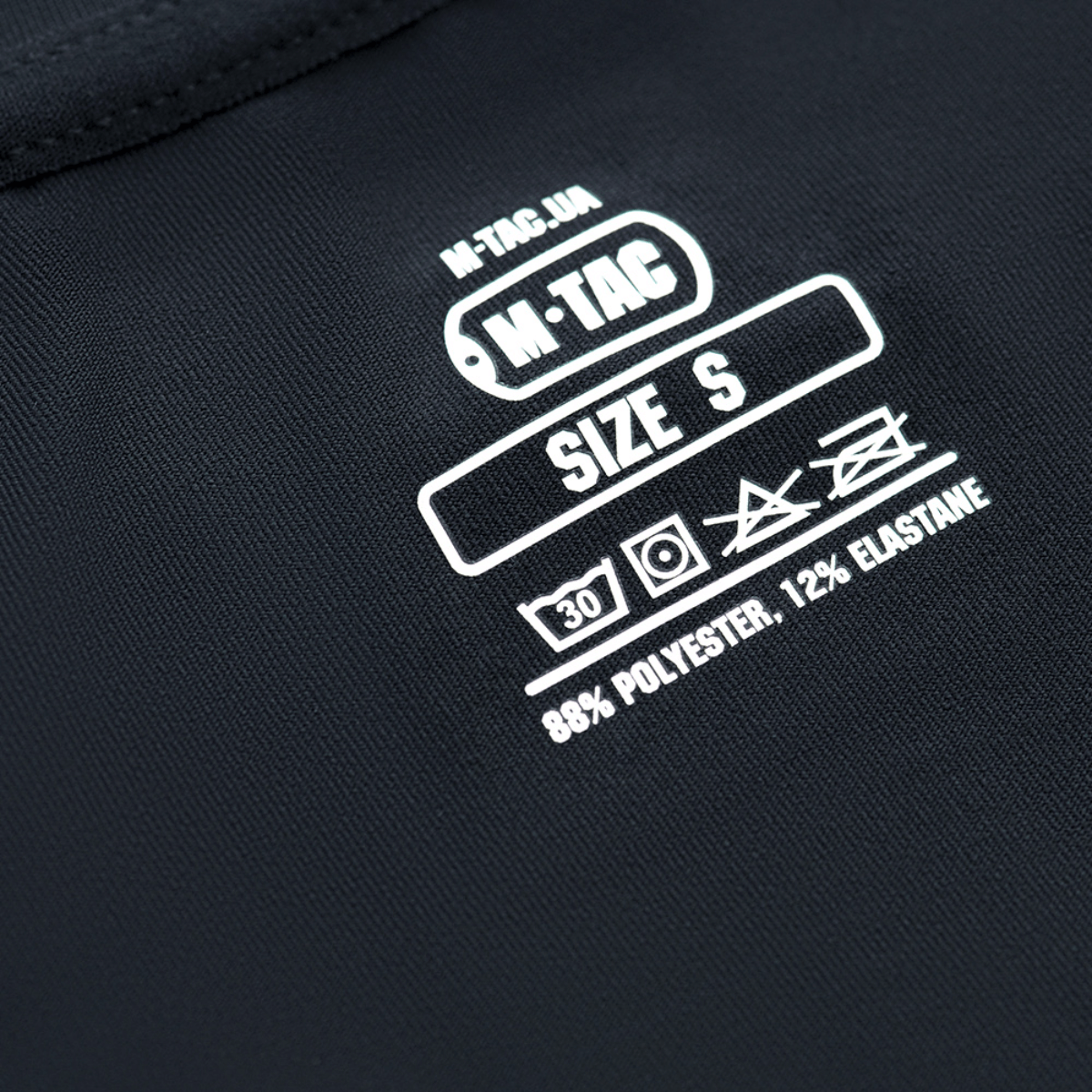 Etiketten på M-Tac Undertøj Active Level I viser materiale og plejeinstruktioner, fremstillet af 88% polyester og 12% elastan.