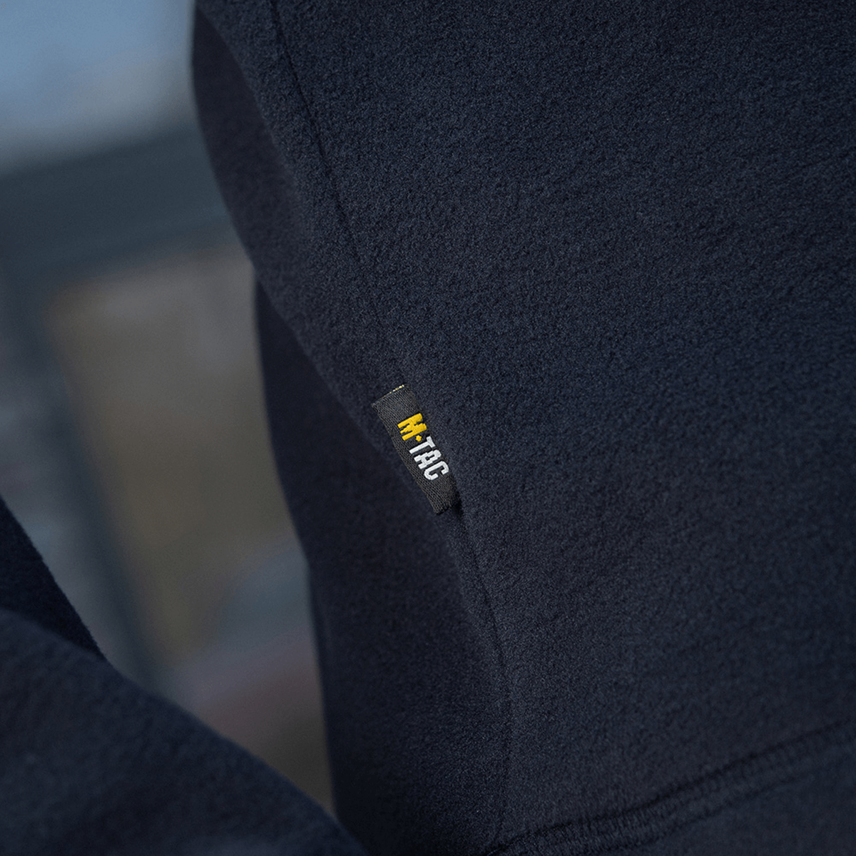Nærbillede af M-Tac Delta Polartec Fleecejakke i mørkeblå, fokuseret på mærkeetiketten.