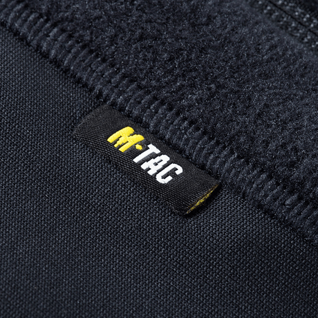 Nærbillede af M-Tac Polartec Sport Fleecejakke label på sort fleecejakke, der viser jakken af høj kvalitet og komfort.