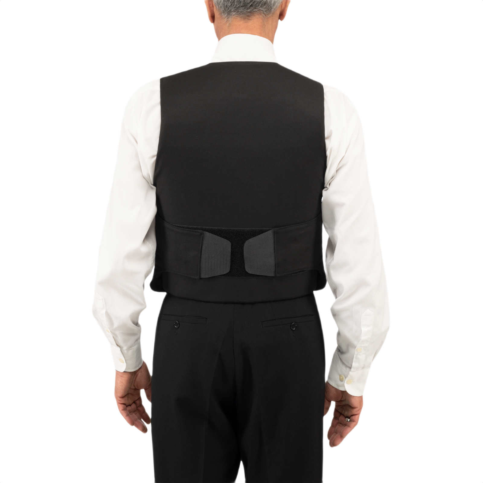 Anorak Titanium® VIP I Stik og Skudsikker Vest med rygsikring, designet til lav synlighed og omfattende kropsdækning, set bagfra. Sort vest, hvid skjorte.