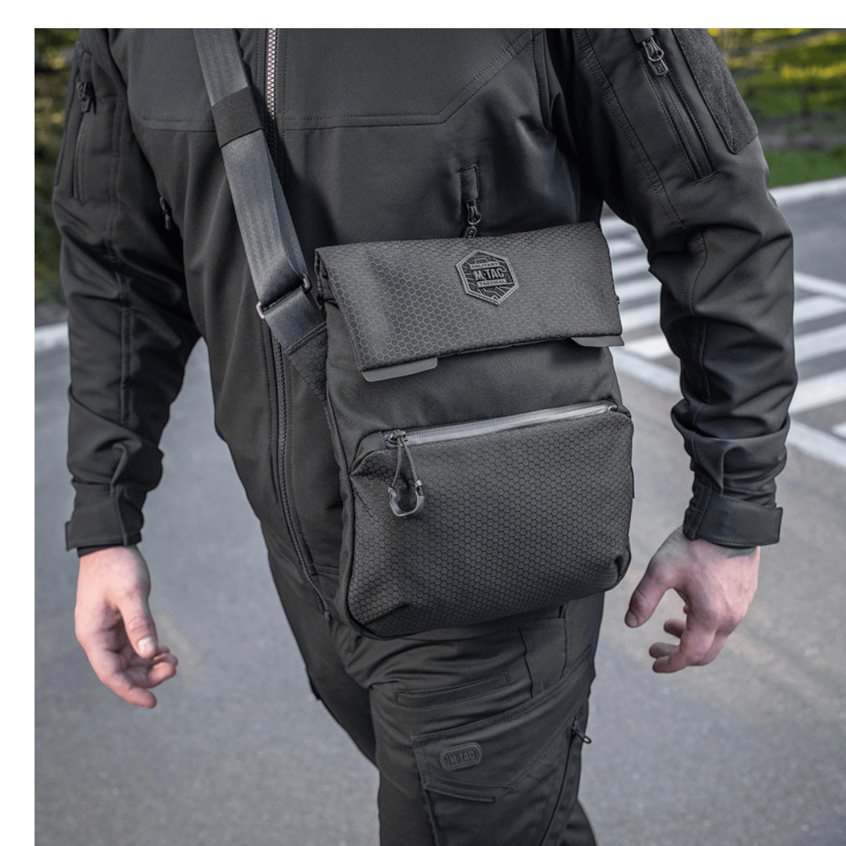 Mand bærer M-Tac Konvert Taske Elite i sort med justerbar skulderrem, fremstillet af slidstærk Cordura 500D og Cordura Hex 1000D.