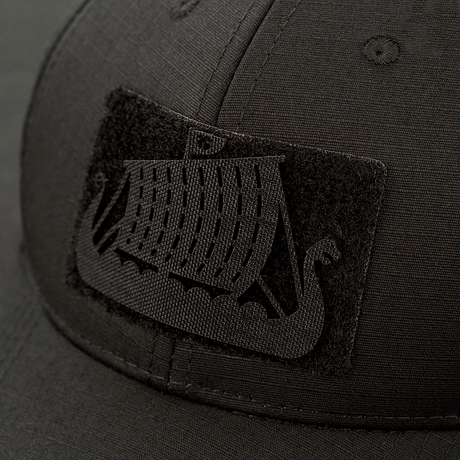M-Tac Patch Drakkar Laser Cut – viikinkilaiva kiinnitettynä mustaan lippikseen, näyttää yksityiskohtaisen lohikäärmiveneen designin leikattuna Cordura 500D:stä.
