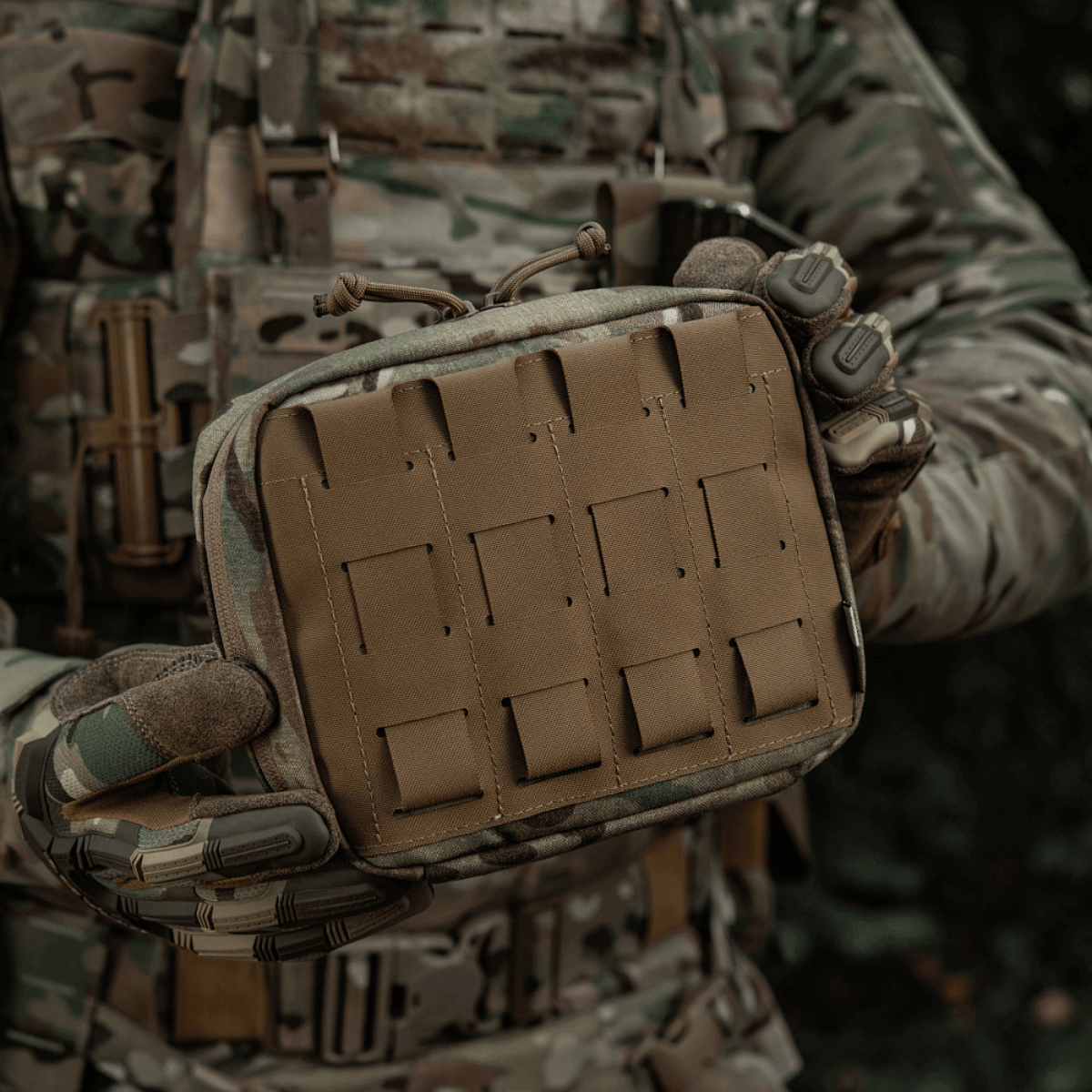 Taktisk M-Tac organizer pouch Elite holdt af person i camouflagetøj, ideel til førstehjælpsudstyr eller nødudstyr gennem M.O.L.L.E-systemet.