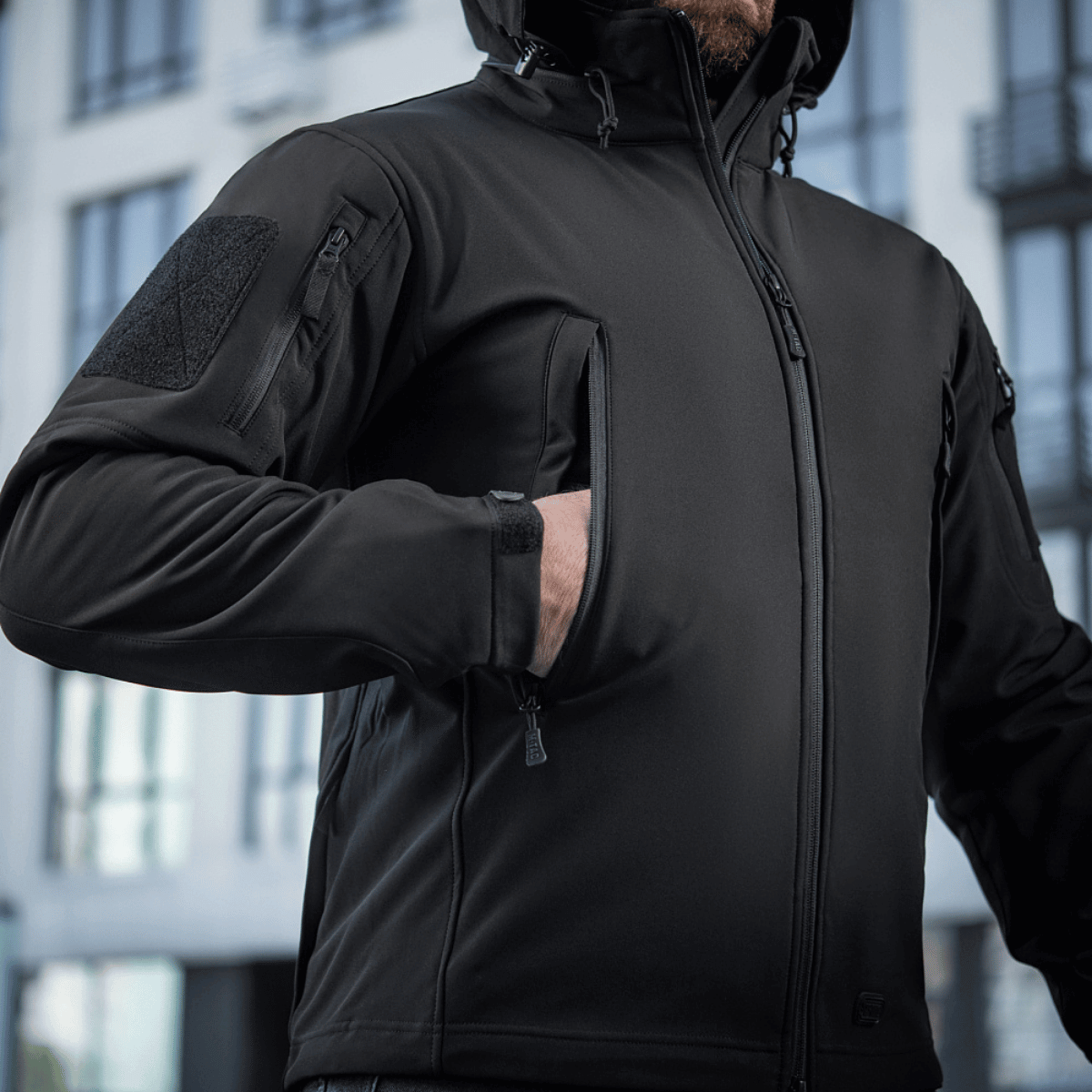 M-Tac Soft Shell Jakke i urban miljø, viser funktionel jakke med lynlås og lommer, ideel til beskyttelse mod dårligt vejr.