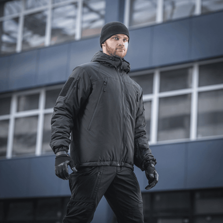 Mand iført M-Tac Alpha Gen.III Pro Vinterjakke i bymiljø, optimal til ekstreme forhold med komfort og vandafvisende materiale.