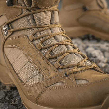 M-Tac Taktiske Sæsonstøvler nupukista ja Cordura®-materiaalista, ihanteelliset maastoon ja ulkokäyttöön, näyttää tukevan nauhoituksen ja yksityiskohtia.
