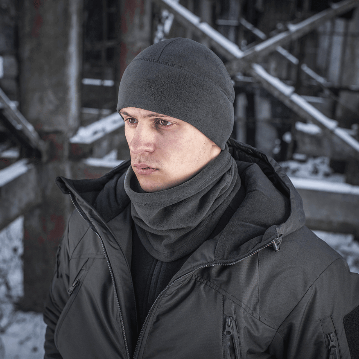 Mand iført M-Tac Anatomisk Tube Scarf med Snor Polartec i et vintermiljø, viser alsidigheden og beskyttelsen af det varme halstørklæde.