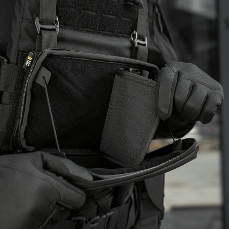 Henkilö avaa M-Tac Admin Pouch Large Elite Gen.II:n, jossa suuri säilytystila varusteille; valmistettu Cordura 500D:stä.