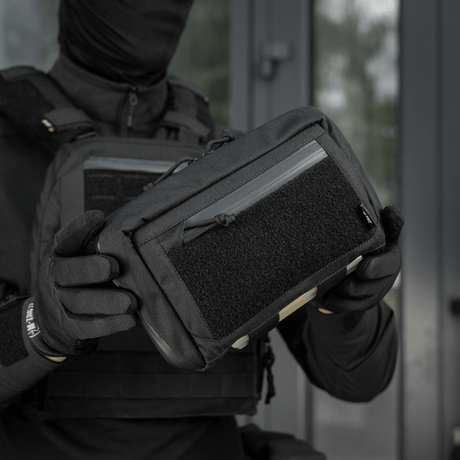 Henkilö pitää M-Tac Admin Pouch Large Elite Gen.II:ta; suunniteltu säilytykseen modulaarisilla lisävarusteilla ja Cordura 500D -materiaalilla.