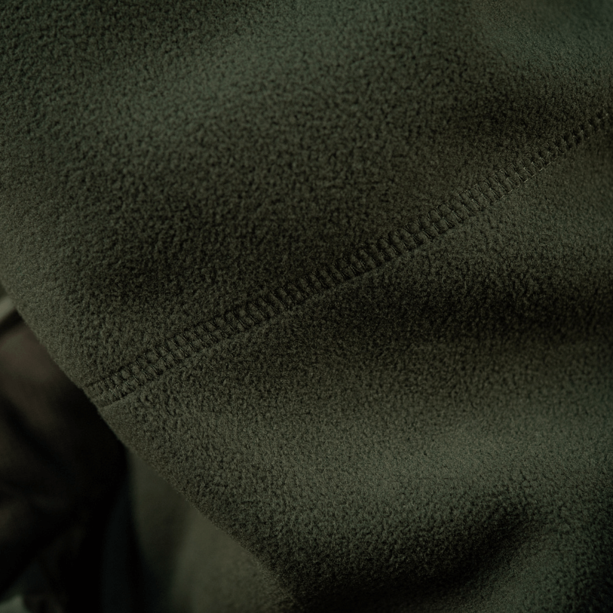 Nærbillede af M-Tac Anatomisk Snood Justerbar Elite Fleece (320 g/m²) detaljer i blødt grønt fleece med syninger.