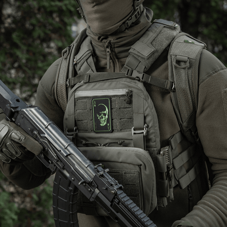 Henkilö jolla M-Tac Patch Face of War (Broderi) liivissä, kirjailtu kallo, innoittunut Vietnam-korteista, Velcro-kiinnitys, taktinen varustus.