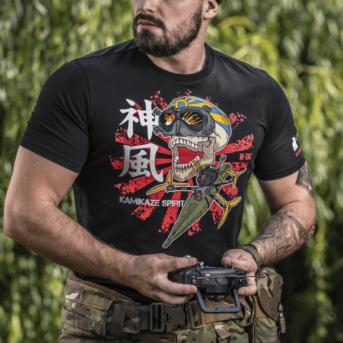 M-Tac T-Shirt Kamikaze Spirit med kranieprint og FPV-goggles, bæres af en person i militærtøj, dedikeret til FPV-operatører.