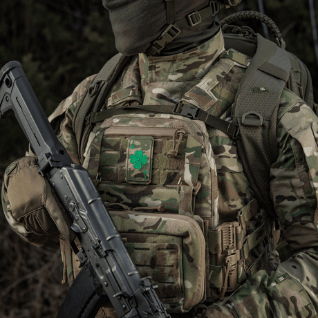 Militaarivarusteet M-Tac Patch Lucky Card (brodeerattu) apilanlehdellä, kiinnitetty Velcrolla maastokuvioituun reppuun.