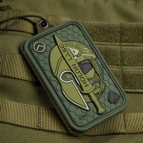 M-Tac Patch Molon Labe 3D PVC spartalainen kypärä ja miekka, kiinnitetty taktiseen laukkuun Velcro-kiinnityksellä.