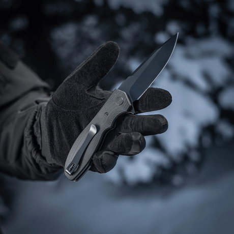 M-Tac Outdoor & Militær taitettava veitsi – Type 6, en, lumipeitteisessä ympäristössä, mustahanskalla pidetty.