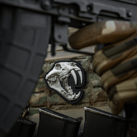 Yksityiskohtainen M‑Tac Patch Old Tiger PVC-patch tigerikraniumilla ja 3D-efektillä, kiinnitetty sotilasvarusteisiin velcrolla.