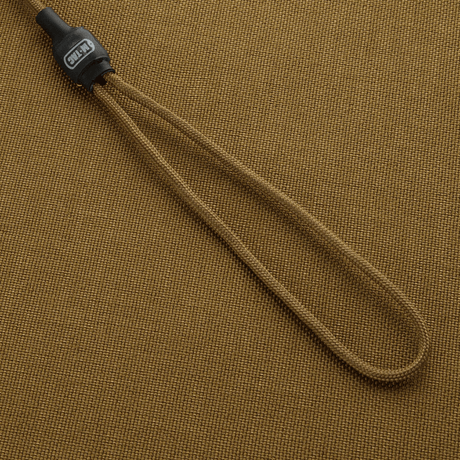 M-Tac Safety Cord Medium Universal kiinnitetty beigen taustalle, joustava spiraalirakenne varusteiden turvaamiseen.
