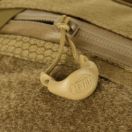 Yksityiskohta M-Tac Sling -pistoolilaukku Elite Hex Velcro, vetoketju ja kantokahva logolla, valmistettu kestävästä Cordura-materiaalista.