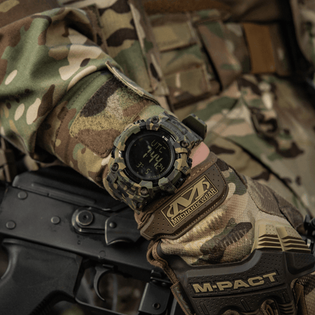 M-Tac Tactical Ur 2037 maastokuvioisessa ranteessa, näyttää tukevan muotoilun, LED-taustavalon ja taktisia toimintoja.