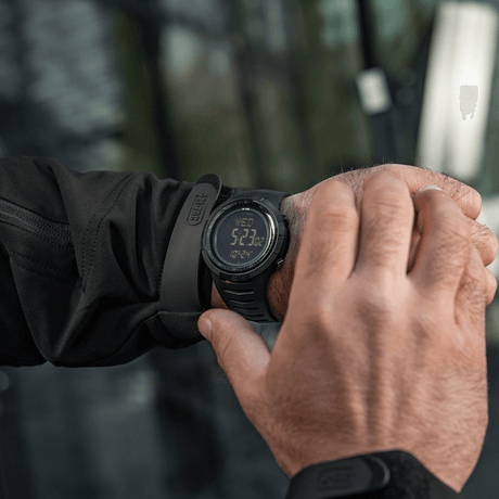 M-Tac Tactical Ur 2147 ranteessa luonnossa, tukeva muotoilu ulko- ja taktiseen käyttöön, sisältää kompassin ja LED-valon.