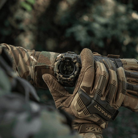 M-Tac Tactical Ur 2037 käytössä luonnossa, näkyy ranteessa henkilöllä maastovaatteissa, näyttää LED-taustavalaistun näytön ja toiminnot.