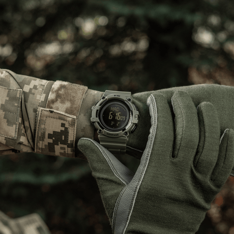 M-Tac Tactical Ur med Kompas 2233 sotilaan ranteessa ulkona, kestävä muotoilu, LED-valaistus ja 5ATM vedenkestävyys.