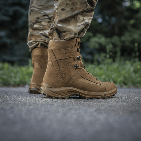Lähikuva M-Tac taktiset kesäsaappaat miehellä camo-housuissa, valmistettu kestävästä nahasta ja Cordura®-verkosta, sopii lämpimiin päiviin.
