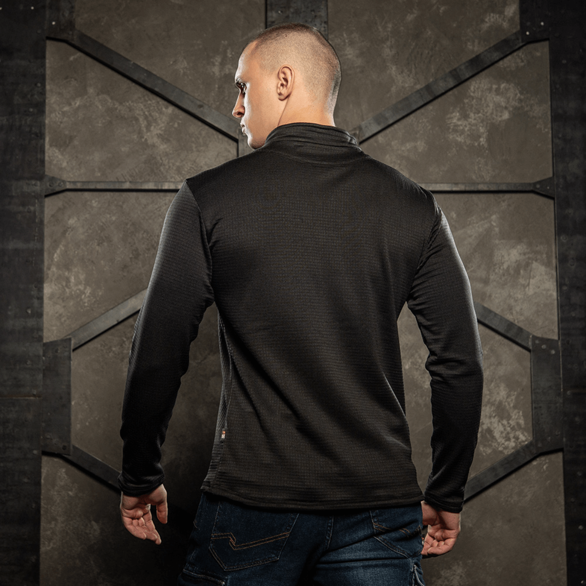 Mand iført M-Tac Thermal Fleece Trøje Delta Level 2, set bagfra, i barsk klimaindstilling. Perfekt til ECWCS lag.