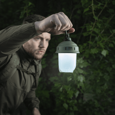 Mies pitää M-Tac retkeilyriippuvalaisinta metsässä, ihanteellinen retkeilyyn, kalastukseen ja metsästykseen 200 lumenin LED-valolla.
