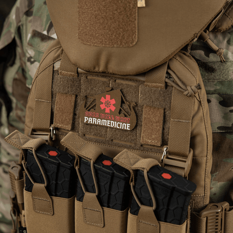 M-Tac Patch Viking Evac taktisessa liivissä, maastotausta, sisältää ensihoitoembleemin.