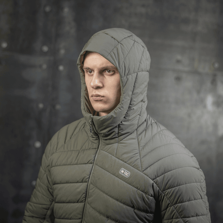 Mand iført M-Tac Jarl Jakke til mellemsæson i grøn, designet til varme og komfort med Toray nylon og G-Loft isolering.